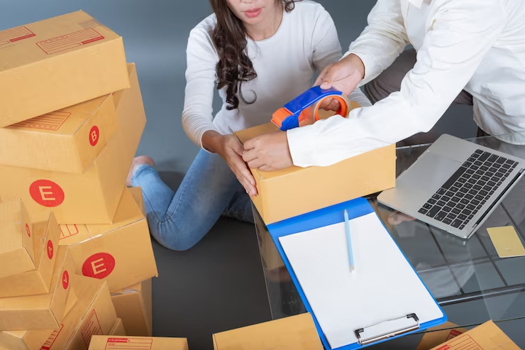 A imagem mostra duas pessoas organizando encomendas com o objetivo de representar a logística para e-commerce.